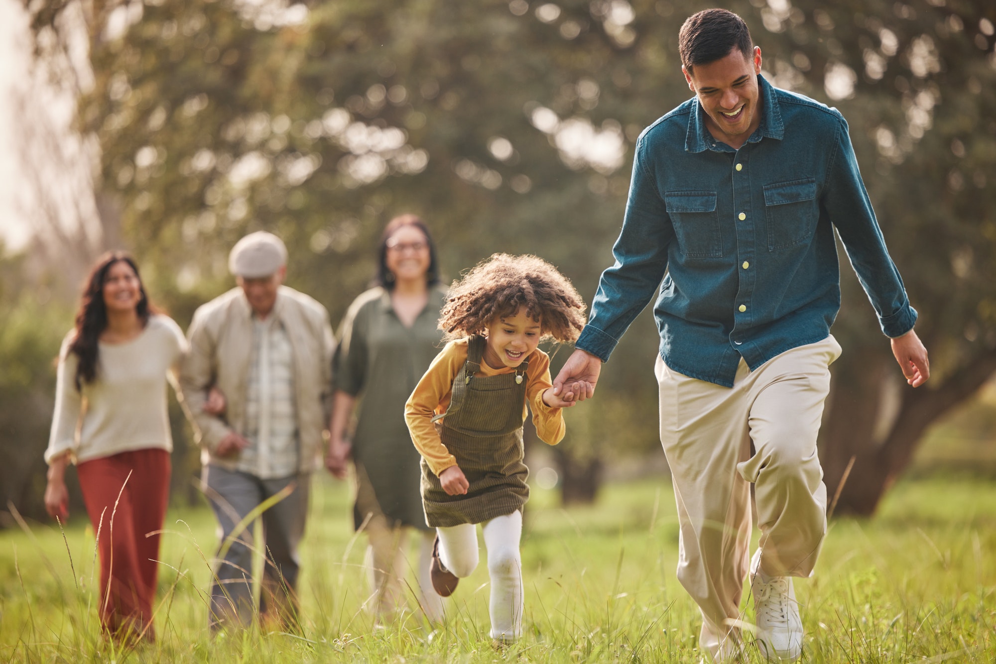 Family, park and parents with children in nature for playing, bonding and running together in field